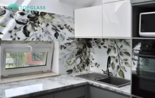 Przestronna kuchnia z artystycznymi panelami szklanymi Lacobel z motywem kwiatowym, nadającym wnętrzu lekkości i nowoczesnego charakteru.